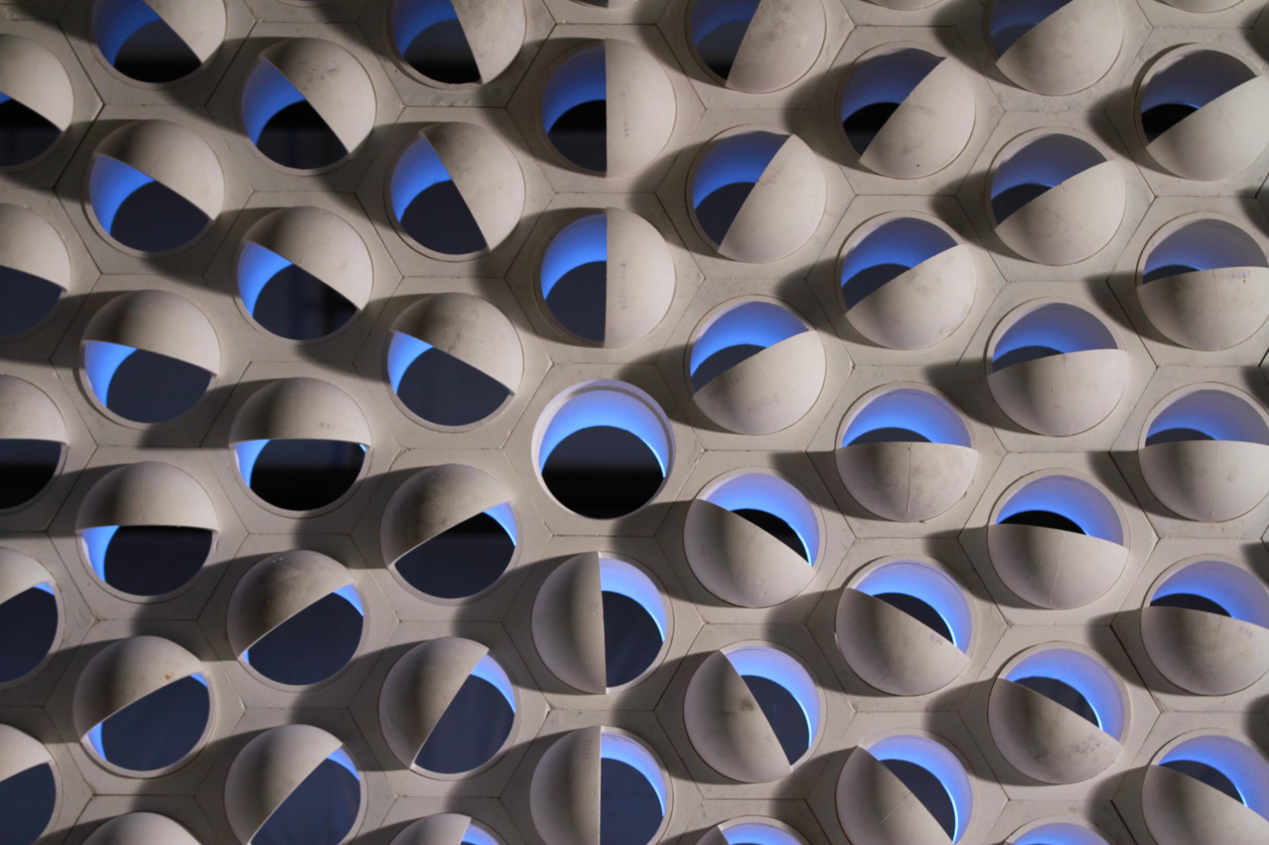 A ceramic wall backlit in blue 